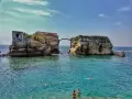 L'isola di Gaiola, con le sue rovine suggestive e il mare cristallino, accoglie bagnanti e nuotatori in una giornata di sole.
