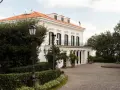 Villa signorile a San Giorgio a Cremano, con tetto arancione, colonne bianche e un viale acciottolato.