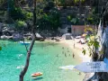 Segnale per le spiagge di Caldane, Isola del Giglio, indica un angolo di paradiso con gente che nuota nell'acqua cristallina.