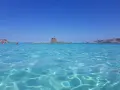 Acque cristalline e un'antica torre su un isolotto: ecco la spiaggia più bella d'Italia, un paradiso azzurro.