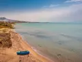 Spiaggia di Licata con barca blu e mare calmo. Un paesaggio da esplorare, tra terra e acqua cristallina.
