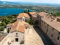 Antico borgo di Populonia centro storico, con vista sul golfo e colline verdi.