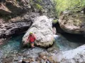 Esploratrice sorridente nel canyon dell'Orrido di Botri, tra rocce imponenti e acque cristalline.