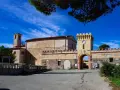 Antico borgo sull'isola di Pianosa, con torre dell'orologio e campanile sotto un cielo azzurro.