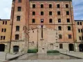 La risiera di San Sabba, un imponente edificio in mattoni con finestre vuote, testimonia un passato di sofferenza.