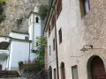 L'eremo di Calomini, incastonato nella roccia, con la sua torre campanaria bianca e gli edifici in pietra, invita alla contemplazione.