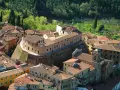 Borgo fortificato con case in pietra e tetti rossi, un campanile e un orologio. Un'ottima meta per scoprire cosa vedere vicino Pisa.