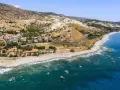Paesaggio mozzafiato sulla costa ionica Calabria: case con tetti rossi, spiaggia rocciosa e mare blu intenso.