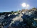 Fumarole attive nel **Val di Cecina**, con vapore che sale tra le rocce sotto un sole splendente.
