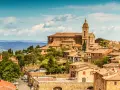 Panoramica di Montalcino con la sua imponente cattedrale e le colline toscane. Un luogo incantevole da scoprire, tra le cose da vedere a Montalcino e dintorni.