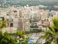 Vista panoramica del montecarlo centro storico, con palazzi color pastello e vegetazione lussureggiante che scende verso il mare.