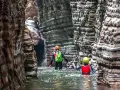 Esploratori in un canyon, tra rocce stratificate e acqua limpida, attraversano i **stretti di giaredo**.