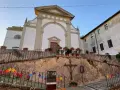 Terricciola cosa vedere: la chiesa parrocchiale domina la piazza, con un'antica croce e festoni colorati che creano un'atmosfera suggestiva.