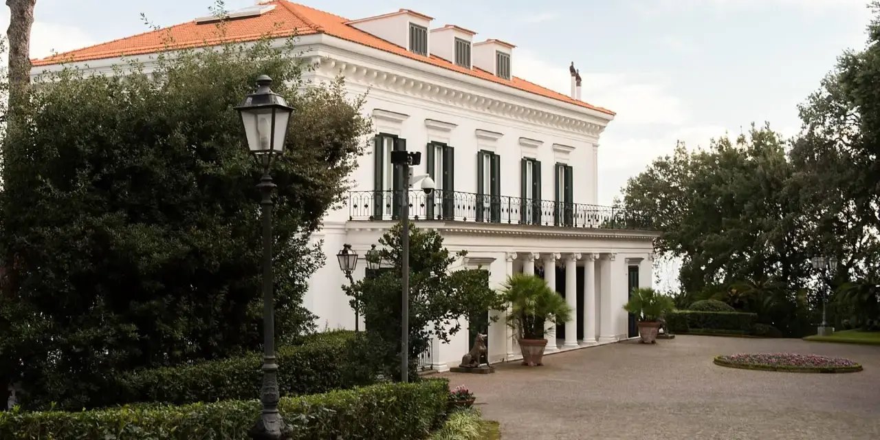 Villa signorile a San Giorgio a Cremano, con tetto arancione, colonne bianche e un viale acciottolato.
