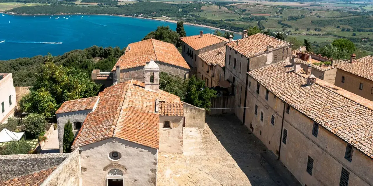 Antico borgo di Populonia centro storico, con vista sul golfo e colline verdi.