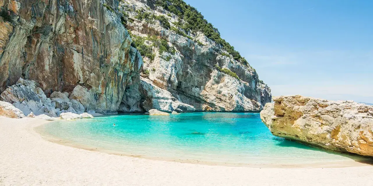 Una delle 10 spiagge più belle d'Italia: sabbia bianca, acque cristalline e imponenti scogliere.