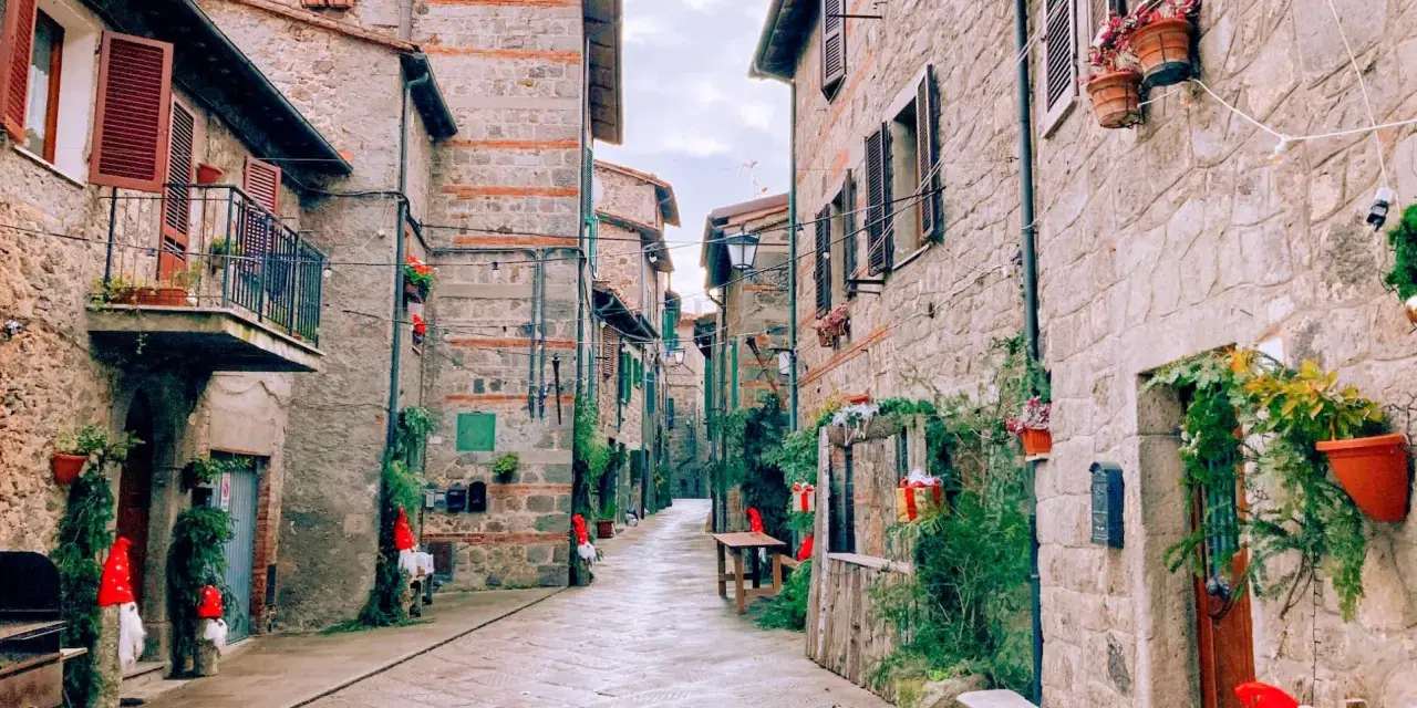 Un vicolo suggestivo ad Abbadia San Salvatore, con case in pietra e decorazioni natalizie. Scopri cosa vedere in questo borgo incantevole.
