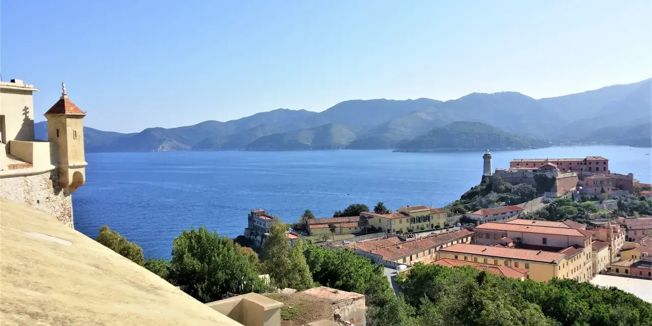 Panoramica di Portoferraio centro storico cosa vedere: fortezze, mare blu e colline verdi.