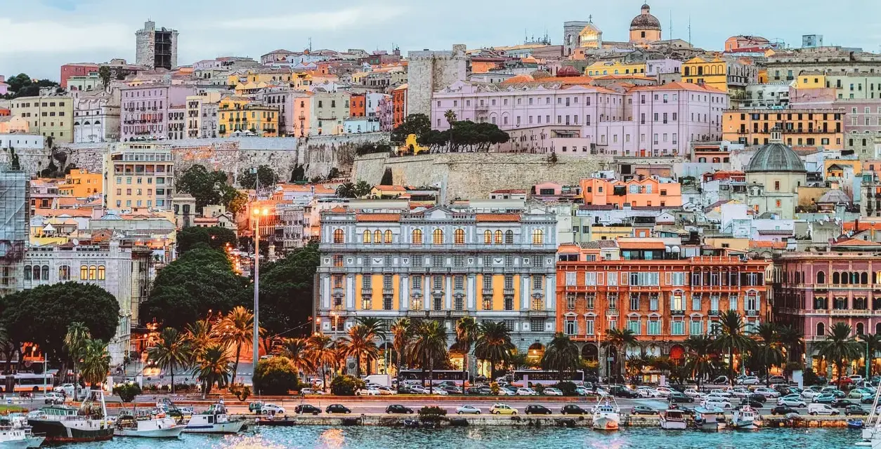 Vista del porto di Cagliari con edifici colorati e palme. Perfetto per scoprire cosa fare a Cagliari.
