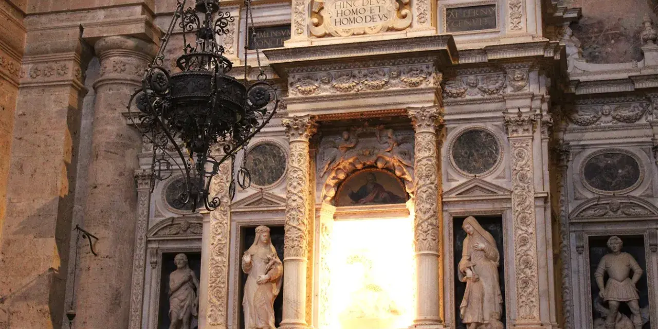 Interno della chiesa di San Biagio (Montepulciano): statue, affreschi e un lampadario in ferro battuto.