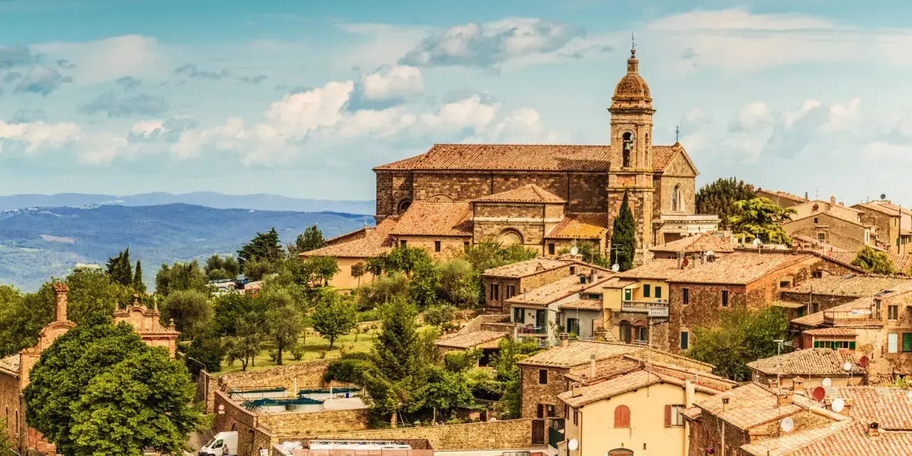 Panoramica di Montalcino con la sua imponente cattedrale e le colline toscane. Un luogo incantevole da scoprire, tra le cose da vedere a Montalcino e dintorni.