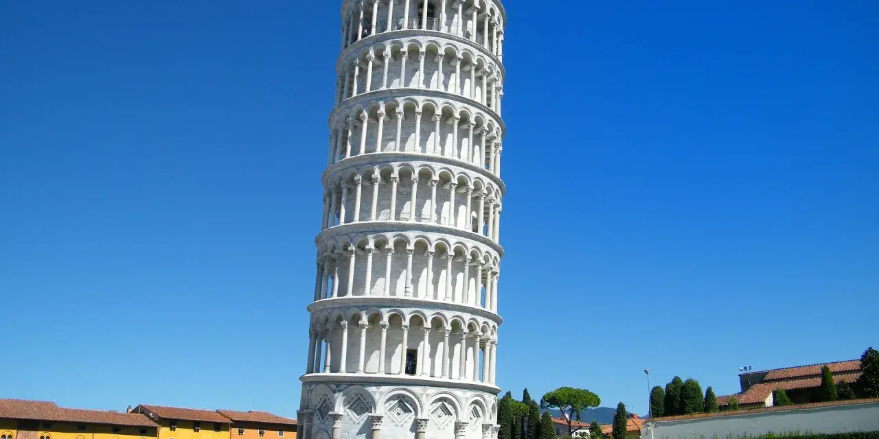 Il **schiefe Turm von Pisa** si ergege con la sua inclinazione iconica sotto un cielo azzurro, circondato da turisti che ammirano la sua bellezza.