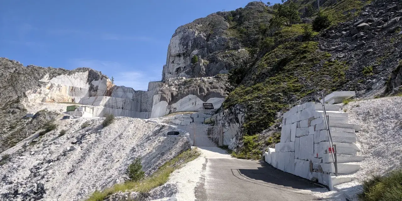 Una cava di marmo con un imponente passo del vestito di blocchi di pietra bianca.