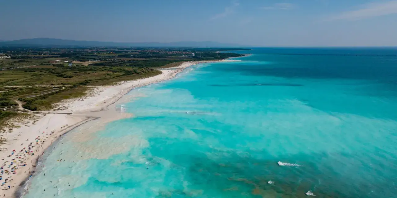 Le spiagge bianche di Rosignano, con acque turchesi cristalline e bagnanti che si godono il sole.