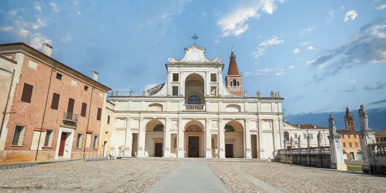 Piazza antistante la Basilica di San Benedetto Po, con la sua imponente facciata e il campanile.