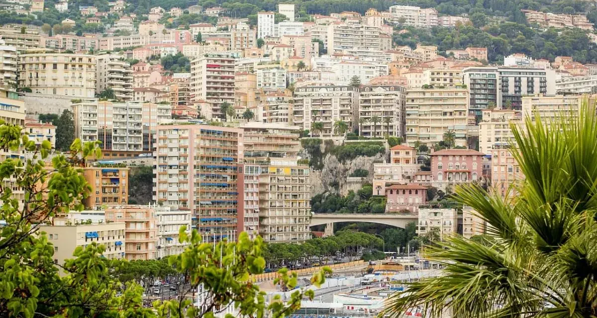 Vista panoramica del montecarlo centro storico, con palazzi color pastello e vegetazione lussureggiante che scende verso il mare.