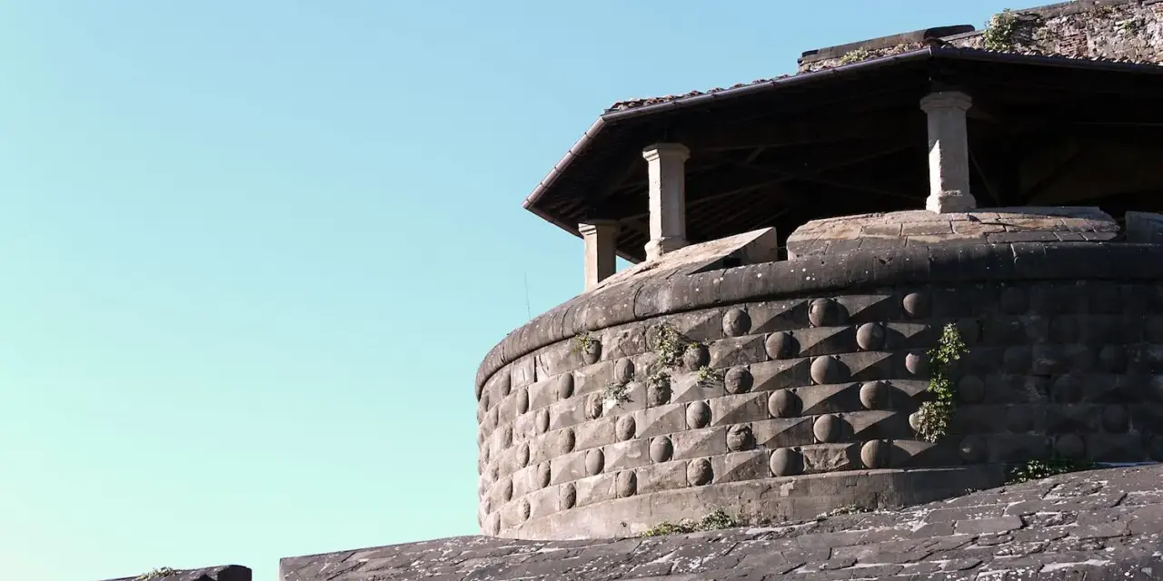 La fortezza da basso, con la sua muratura bugnata e il tetto spiovente sorretto da colonne, si staglia contro il cielo azzurro.