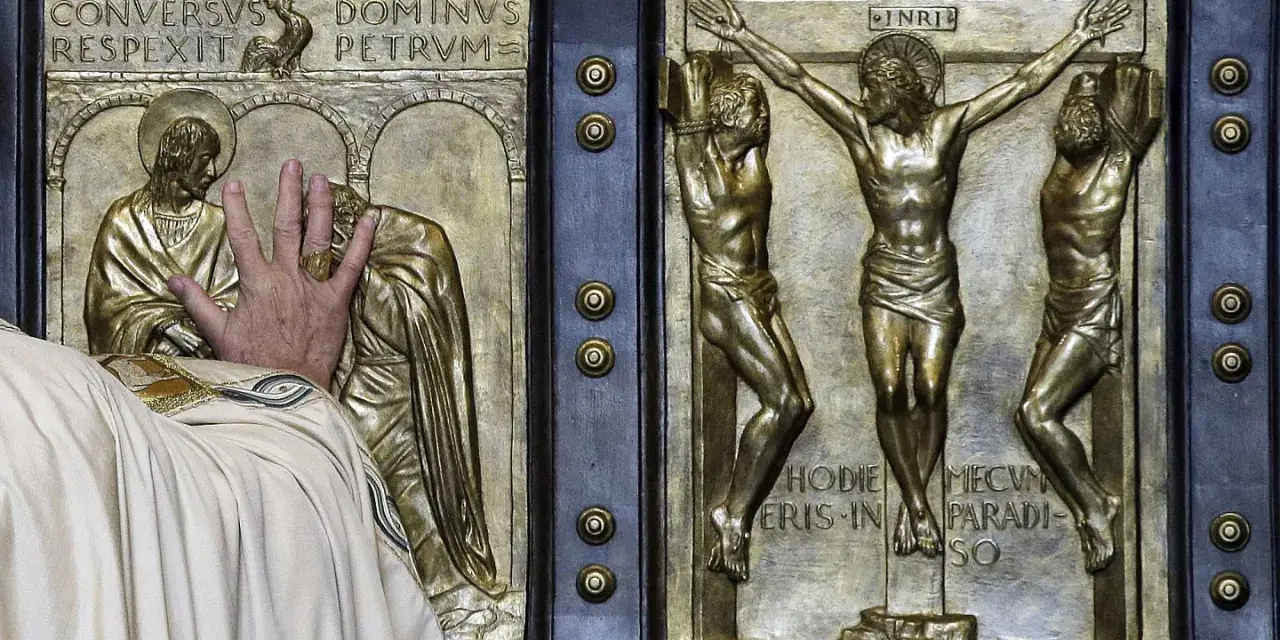 Mano che tocca la porta santa San Pietro, con scene della crocifissione e del rinnegamento di Pietro.