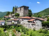 Fivizzano cosa vedere: un borgo medievale con castello, case in pietra e un ponte ad arco su un ruscello.