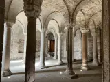 Interno dell'abbazia di San Salvatore: un corridoio con volte a crociera e colonne in pietra, che evocano secoli di storia.