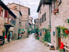 Un vicolo suggestivo ad Abbadia San Salvatore, con case in pietra e decorazioni natalizie. Scopri cosa vedere in questo borgo incantevole.