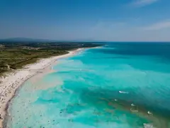 Le spiagge bianche di Rosignano, con acque turchesi cristalline e bagnanti che si godono il sole.