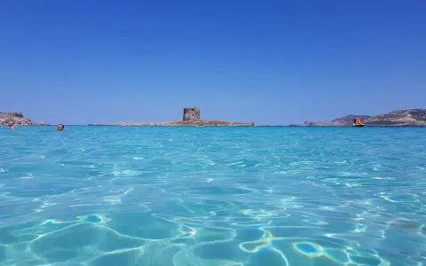 Acque cristalline e un'antica torre su un isolotto: ecco la spiaggia più bella d'Italia, un paradiso azzurro.