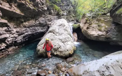 Esploratrice sorridente nel canyon dell'Orrido di Botri, tra rocce imponenti e acque cristalline.