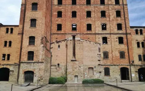 La risiera di San Sabba, un imponente edificio in mattoni con finestre vuote, testimonia un passato di sofferenza.