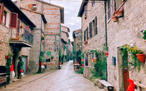 Un vicolo suggestivo ad Abbadia San Salvatore, con case in pietra e decorazioni natalizie. Scopri cosa vedere in questo borgo incantevole.