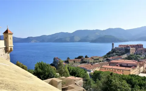 Panoramica di Portoferraio centro storico cosa vedere: fortezze, mare blu e colline verdi.