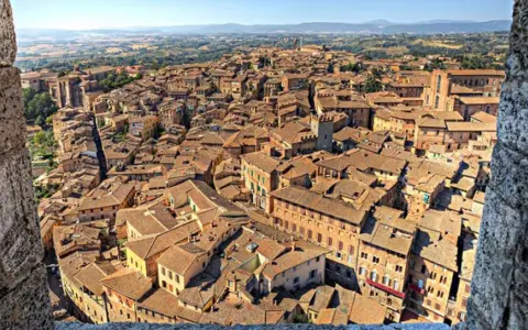 Vista dall'alto di Siena, con la Torre del Mangia che domina il panorama, evocando la sua leggenda.