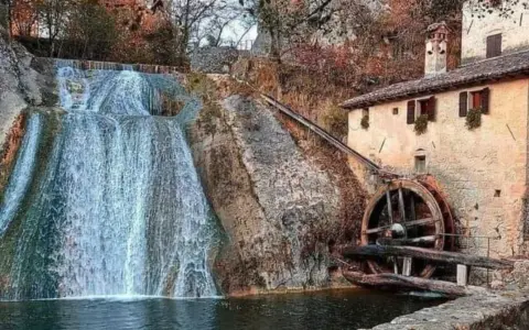 Cascata e antico molinetto della Croda, con la ruota in legno che gira grazie all'acqua.