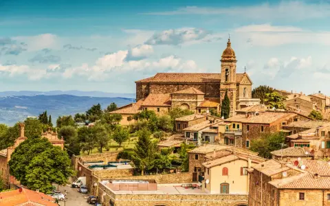 Panoramica di Montalcino con la sua imponente cattedrale e le colline toscane. Un luogo incantevole da scoprire, tra le cose da vedere a Montalcino e dintorni.