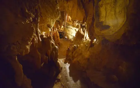 Interno della grotta Maona a Montecatini, con stalattiti e stalagmiti illuminate.