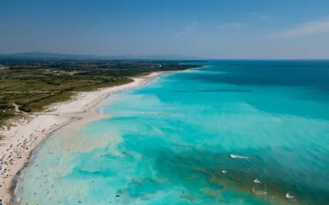 Le spiagge bianche di Rosignano, con acque turchesi cristalline e bagnanti che si godono il sole.