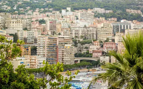 Vista panoramica del montecarlo centro storico, con palazzi color pastello e vegetazione lussureggiante che scende verso il mare.