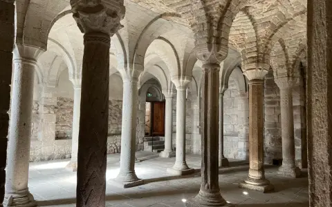 Interno dell'abbazia di San Salvatore: un corridoio con volte a crociera e colonne in pietra, che evocano secoli di storia.