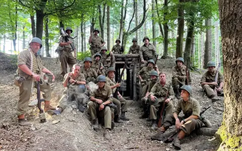 Soldati in uniforme militare, armati e pronti, si riposano in un bosco, forse durante una sosta al passo del giogo.