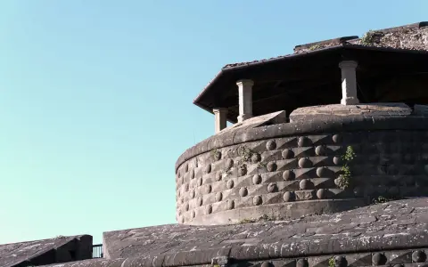 La fortezza da basso, con la sua muratura bugnata e il tetto spiovente sorretto da colonne, si staglia contro il cielo azzurro.